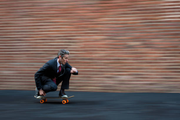 Youthful businessman Motion blurred businessman skateboarding one mature man only audio stock pictures, royalty-free photos & images