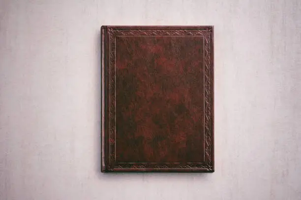 the book in a red cover on a light gray background, top view