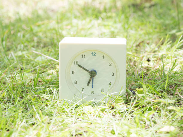 White simple clock on lawn yard, 6:50 six fifty o'clock