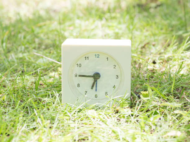 istock White simple clock on lawn yard, 6:45 six forty five o'clock 801559390