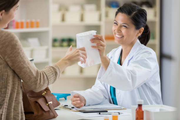 beautiful asian female pharmacist assists customer - prescription doctor rx pharmacist imagens e fotografias de stock