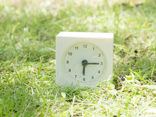 istock White simple clock on lawn yard, 6:15 six fifteen o'clock 801561800