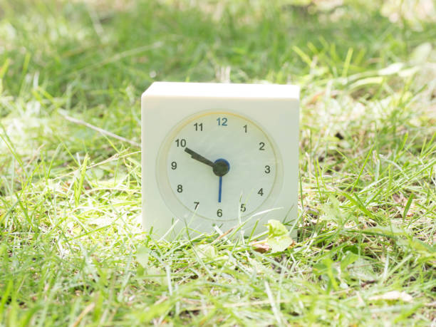 istock White simple clock on lawn yard, 9:50 nine fifty o'clock 801564130