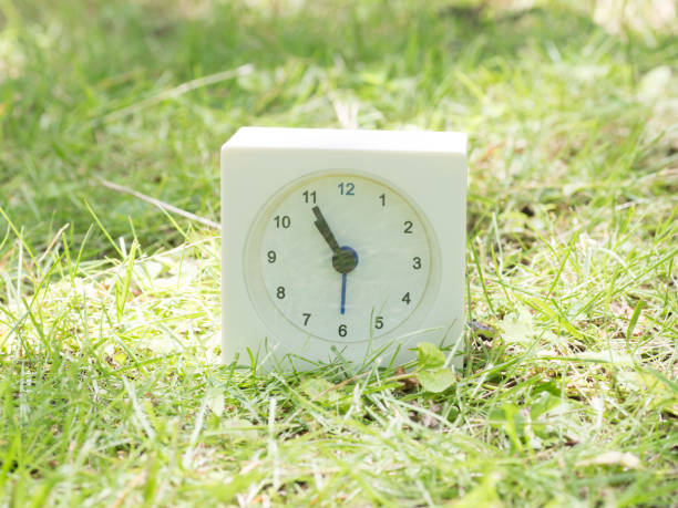 istock White simple clock on lawn yard, 10:55 ten fifty five o'clock 801572034