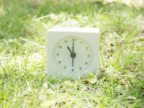 White simple clock on lawn yard, 11:00 eleven o'clock