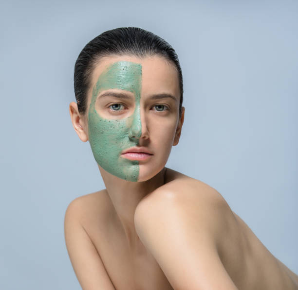 istock Young woman with green face mask - studio portrait 801608024