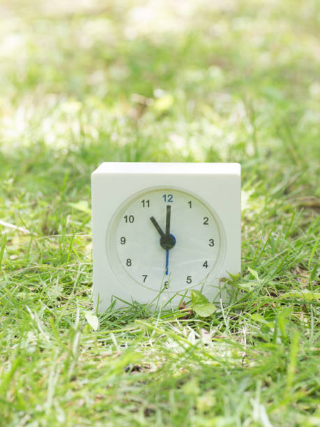 orologio semplice bianco sul cortile del prato, ore 11:00 - ore 12:00 foto e immagini stock