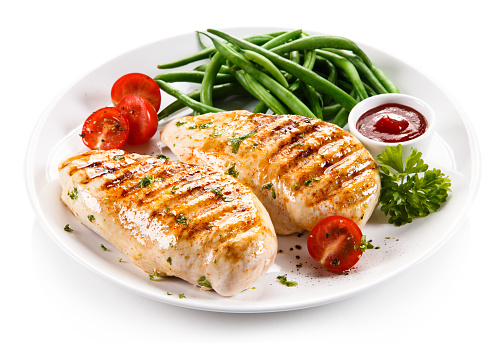 Grilled chicken fillet and vegetables on white background