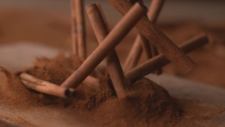 Cinnamon sticks falling into powdered cinnamon