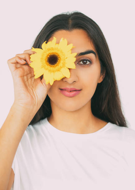 istock Attractive Indian woman hiding eye behind flower 801652946
