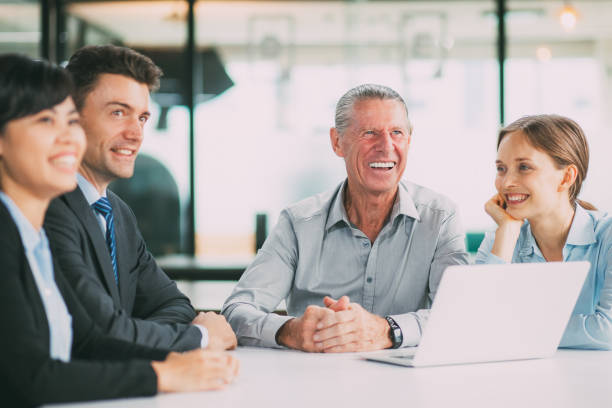 istock Cheerful businesspeople sitting in boardroom 801653080