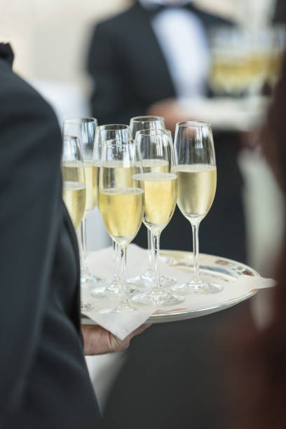 istock Waiter carrying tray with champagne flutes 801655594