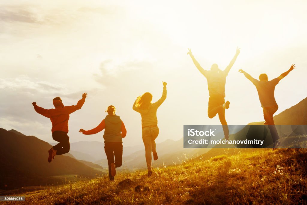 Grupo de amigos felices de correr y saltar - Foto de stock de Felicidad libre de derechos