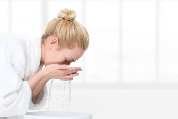 istock Young woman washing her face 801664192