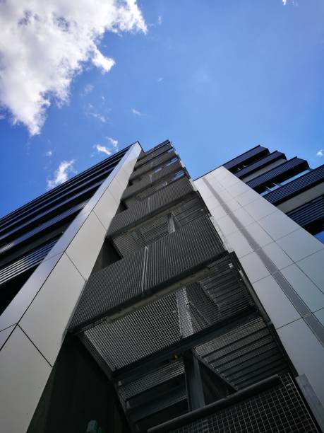 istock Looking up on high administration building with sky and clouds 801680756