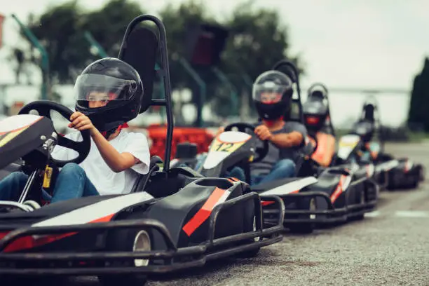 Family go-Karts together. They just finished their race on driveway.