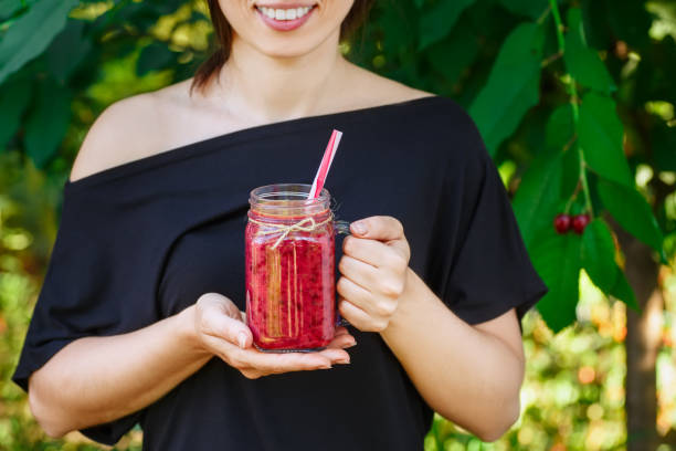 istock girl holding cherry smoothie 801686620
