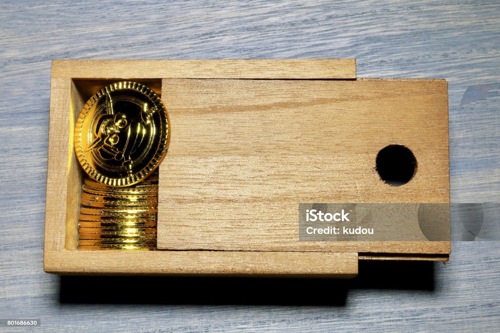 Toy gold coins and wood box Artificial Stock Photo