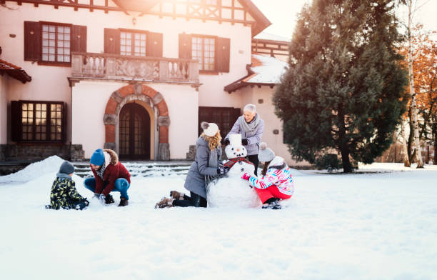 família de geração dois fazendo um boneco de neve - 7651 - fotografias e filmes do acervo