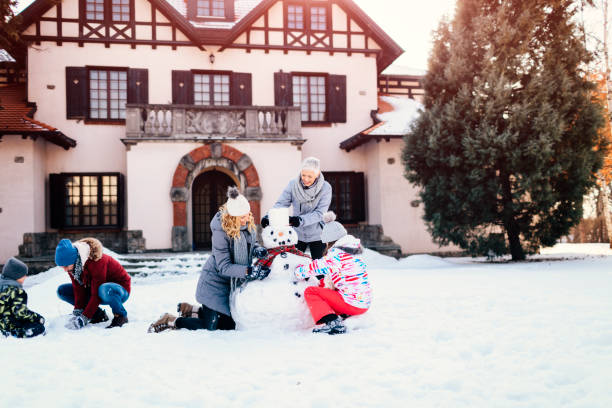 famiglia di due generazioni che fa pupazzo di neve - 7650 foto e immagini stock