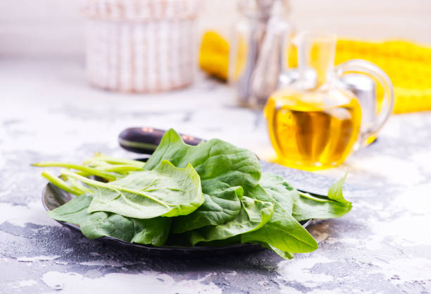 raw spinach raw spinach on plate and on a table spinazie stock pictures, royalty-free photos & images