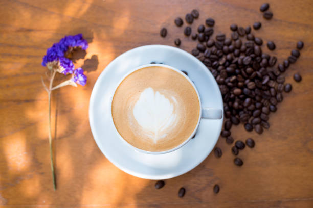 istock Coffee cup and coffee beans on table on a wooden desk 801773672