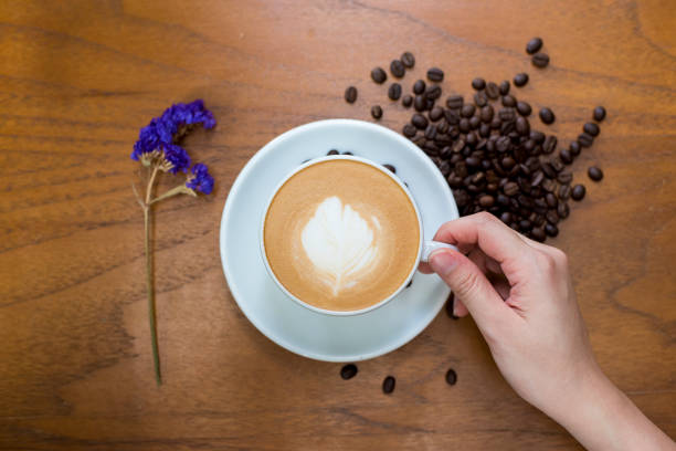 istock Coffee cup and coffee beans on table on a wooden desk 801776328