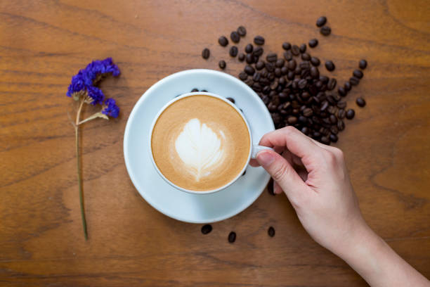 istock Coffee cup and coffee beans on table on a wooden desk 801776824