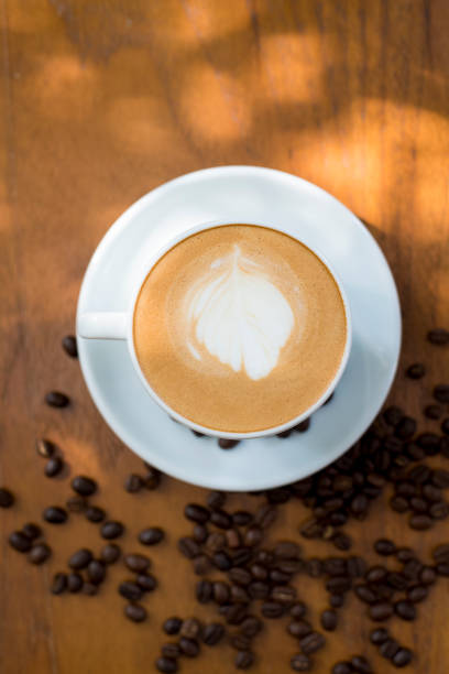 istock Coffee cup and coffee beans on table on a wooden desk 801777446