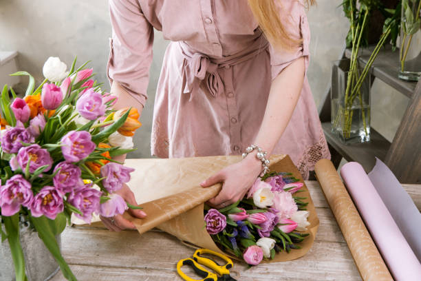 istock Florist pack festive bouquet in wrapping paper. 801808640