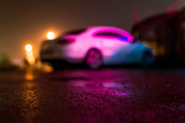 Wet car after rain reflected light from advertising signs. View from the level of asphalt