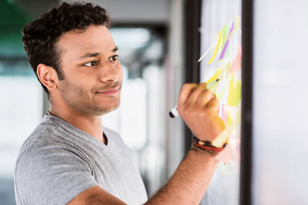 istock Thoughtful male worker writing ideas on small papers 801840098