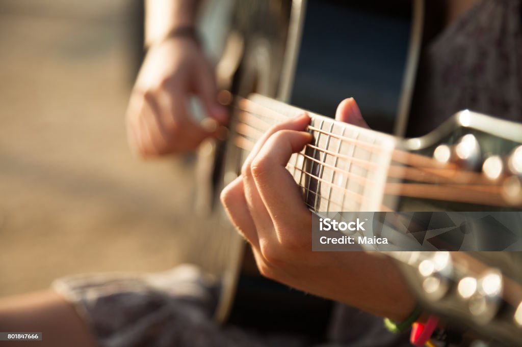 Playing acoustic guitar close-up Teen girl playing acoustic guitar, detail, shallow DOF. Guitar Stock Photo