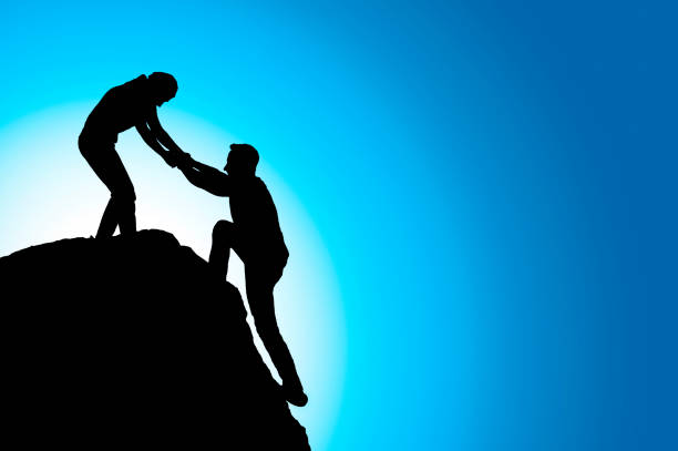 istock Silhouette of helping hand between two climber 801853426