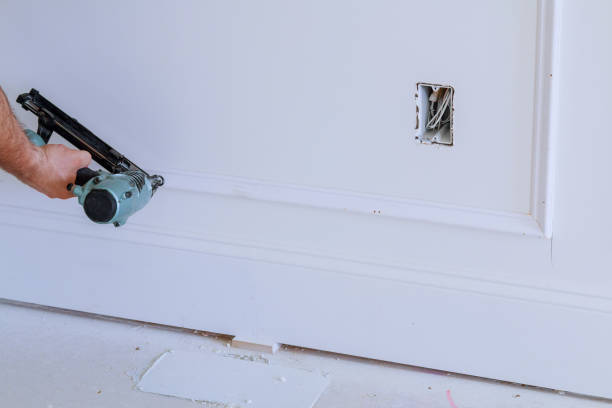 istock Do it yourself home owner repairing frame molding with nail gun, 801855982