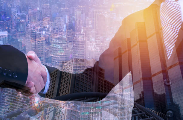 istock business handshake with city background, Double exposure style 801878694