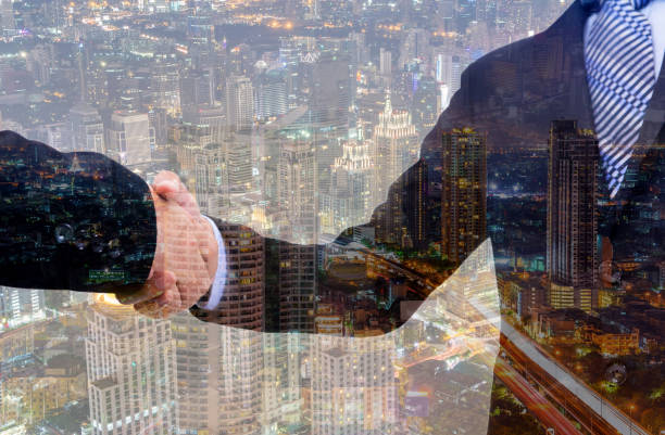 istock business handshake with city background, Double exposure style 801884252