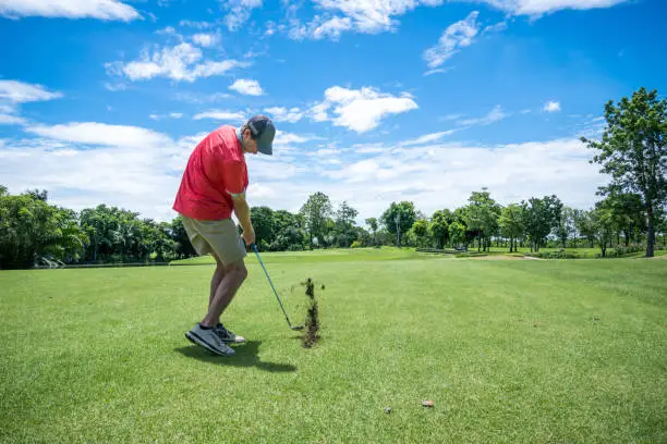 Photo of golfer playing golf with golf club on fairway