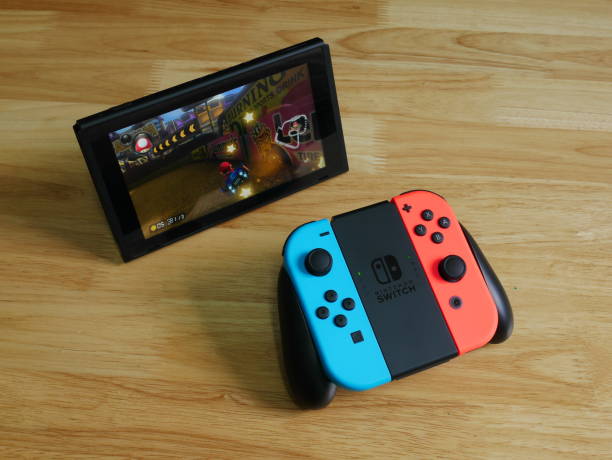 Nintendo Switch And Small Nintendo Switch Lite Comparison Of Two Handheld  Game Consoles Stock Photo - Download Image Now - iStock