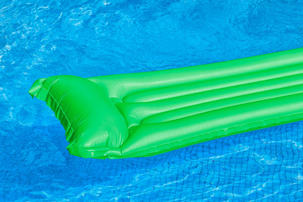 istock Green air mattress floating in a swimming pool. 801924242