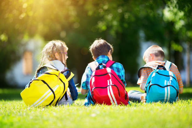 istock Children with rucksacks standing in the park near school 801994716