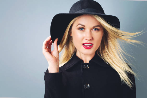 istock Beautiful blonde woman in a black coat 802004902