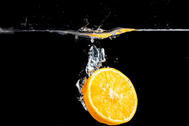 istock orange slice in water splash on black background 802005244