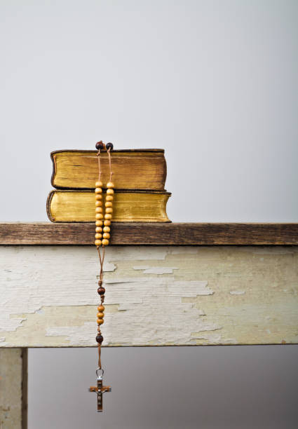 el libro de la iglesia católica liturgia y el rosario de perlas en la mesa de madera - glorification fotografías e imágenes de stock