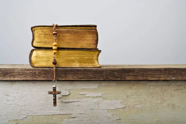 The book of Catholic Church liturgy and rosary beads on the wooden table