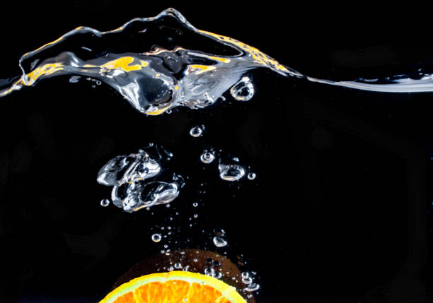 istock orange slice in water splash on black background 802008118