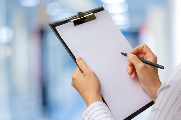 Checklist in the hands of a businesswoman . Checklist in the hands of a businesswoman on a blurred background. clipboard stock pictures, royalty-free photos & images