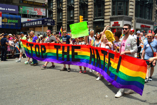 stop the hate - marchers at the gay pride parade in new york - flag rainbow gay pride flag gay man imagens e fotografias de stock