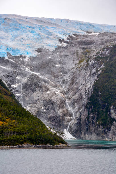The Romanche Glacier on the Beagle Channel, Chile, South America Beagle Channel, Alberto de Agostini National Pa, Chile - February 23, 2016: View of the cascade from the Romanche glacier, in the mountains of the Alberto de Agostini National Park of Chile, flows down into the Beagle Channel. In the so-called Glacier Alley or Avenue of the Glaciers in the northwest arm of the channel, it is a favorite tourist cruise ship passage and designated a Biosphere Reserve by UNESCO. beagle channel photos stock pictures, royalty-free photos & images