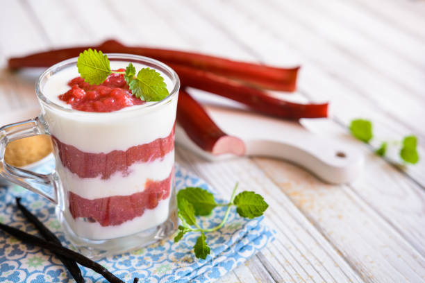 Layered dessert with yoghurt and rhubarb puree in a glass cup